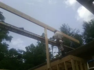 Carpenter setting a ridge beam over a new addition frame — Ice Dam Removal by Roofing Brothers in Cache