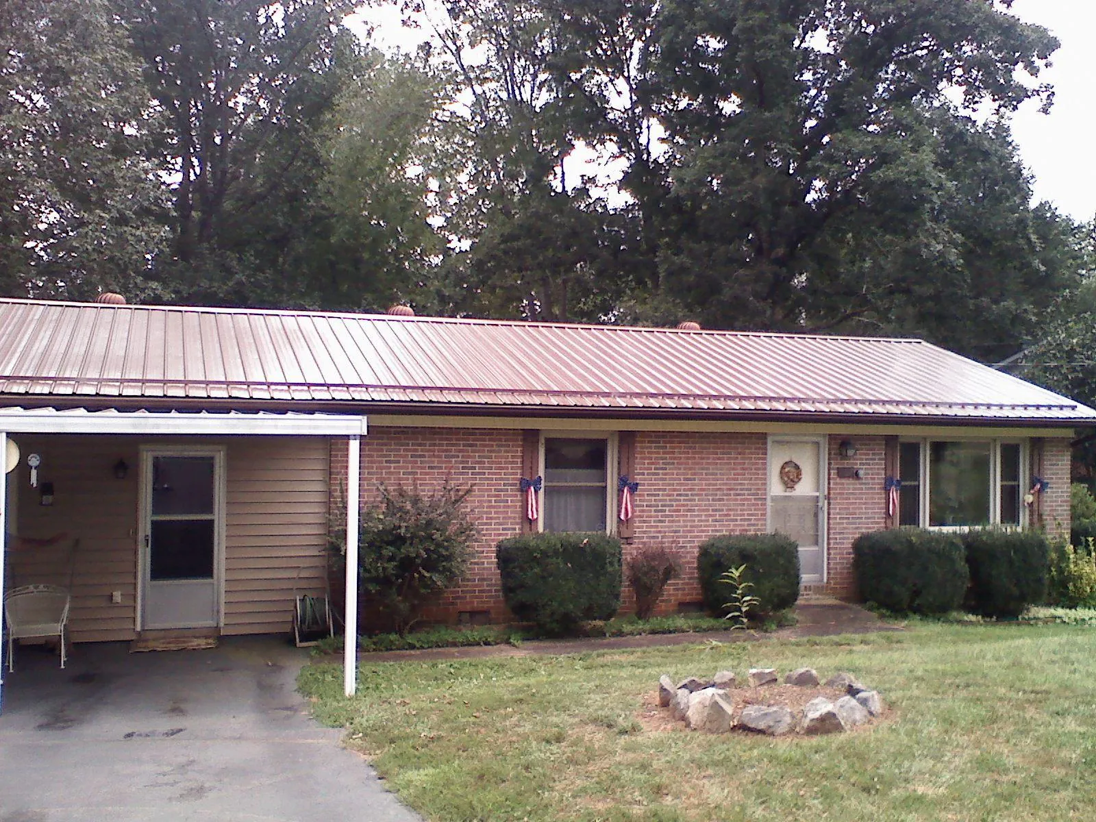 Bronze metal roof and carport on a brick ranch home — Roof Repair work by our crew in Cache